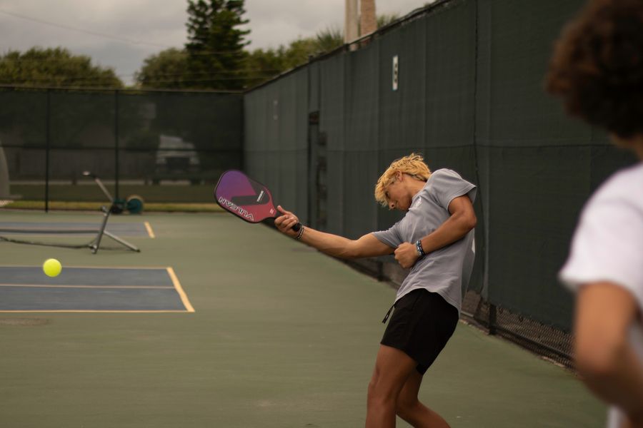A player swinging at a rating event while another looks on